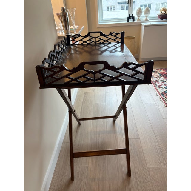 Elegant vintage mahogany butlers tray table featuring a removable rectangular tray with decorative pierced lattice gallery...