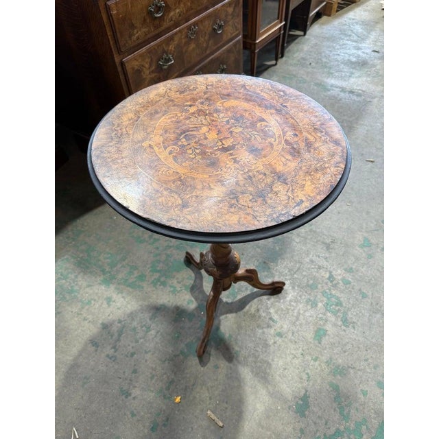 A beautifully crafted Victorian-era walnut occasional table featuring a richly figured circular top adorned with intricate...