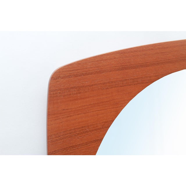 Beautifully designed 1960s wall mirror. Square, rounded base. Teak veneered frame. Mirror in excellent condition.