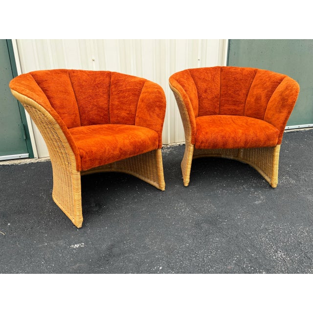 Mid century modern rattan tub chairs with original vintage orange chenille upholstery. These chairs feature a channel back...