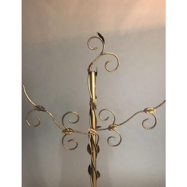 A great vintage gilt metal clothing store display rack. It has a winding vine & leaf design with scrolled arms in a gilt...