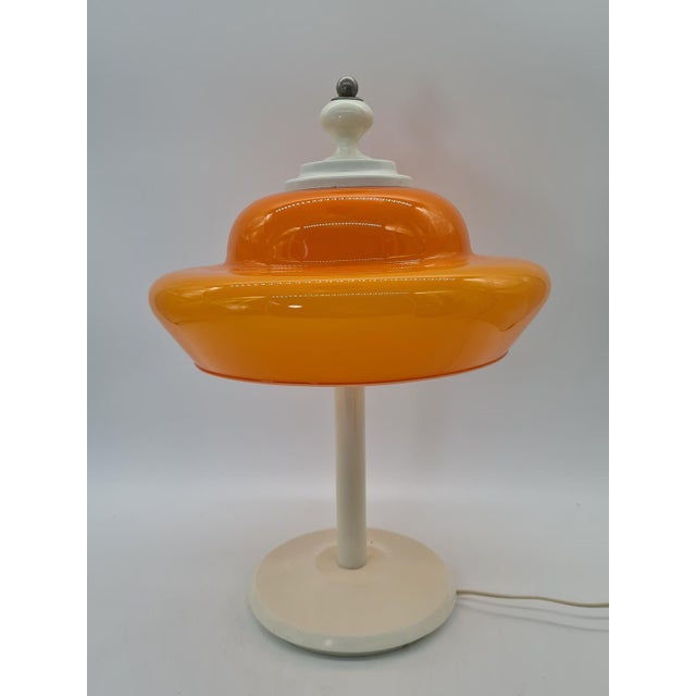 A striking table lamp in the space age/mid-century modern style, made in Europe in the 1970s. Its standout feature is the...