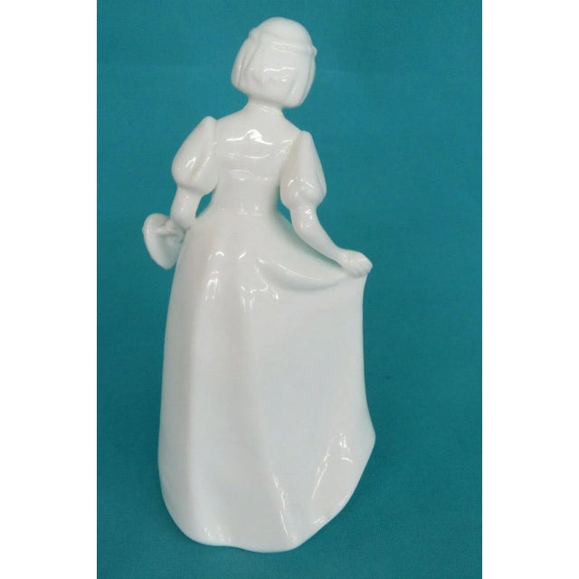 This highly charming Figurine is made of porcelain. This lovely figurine is stamped as having been made in England by the...
