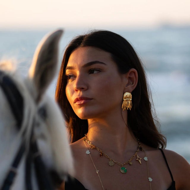 Dive into oceanic elegance with the Mystic Ruby-Eyed Jellyfish Gold Earrings. Inspired by the mesmerizing form of...