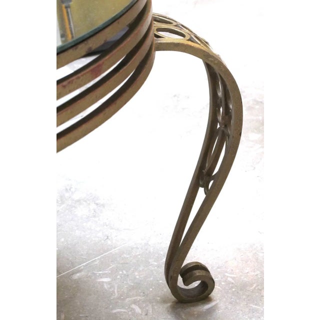 A shapely French Art Deco gilt iron circular table with mirrored top; the original mirrored top above an openwork frieze...