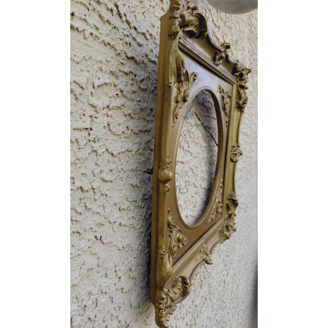 This ornate mid-century square wood gold painted picture frame has a round opening for the artwork in the center. The...