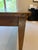 19th-century French provincial farmhouse table, featuring plank construction on the tabletop and breadboard ends. The warm...