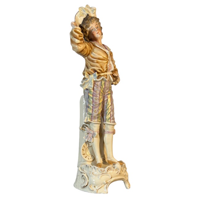 This antique Meissen Style German bisque porcelain figurine depicts a finely sculpted 18th-century young man standing in a...
