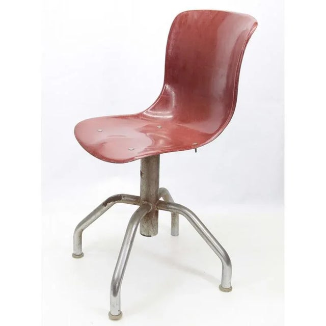 50s turning office chair with ergonomic seat in brownish-red brick-hard plastic and steel underside measures: cm 36 x 82 x...