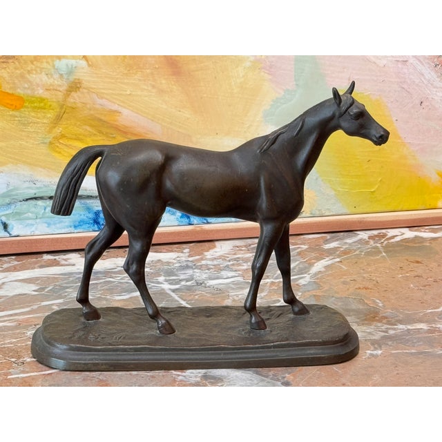 A well-modeled small cast bronze horse standing at rest on an oval naturalistic base, with good dark patina throughout....