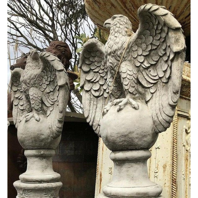 An impressive and highly decorative pair of large eagle sculptures, each dramatically modelled with powerful proportions...