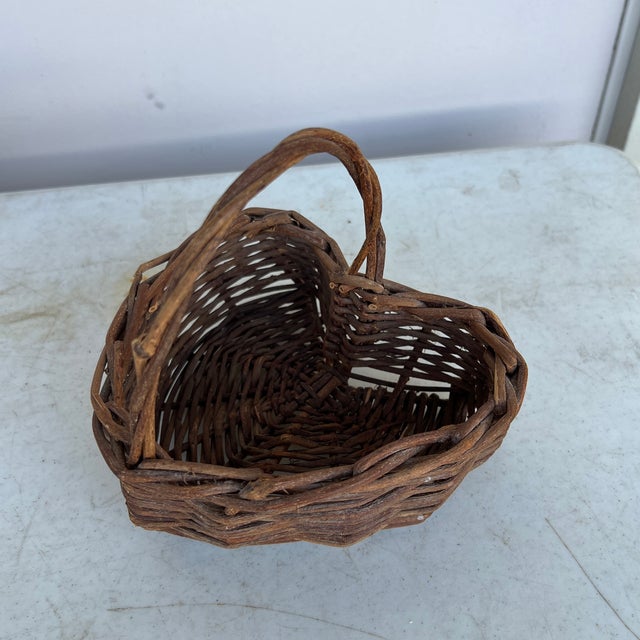 Vintage small rustic handmade basket. This twig, vine weaved basket has the shape of a heart with a handle. Basket...