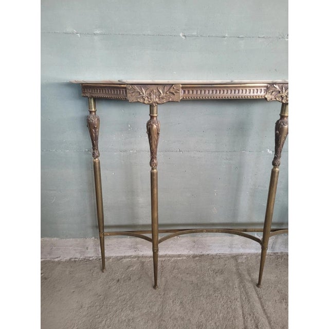 Designer console table, Louis XVI style, in gilded brass and marble top. Period: 1950s Excellent overall condition, with...