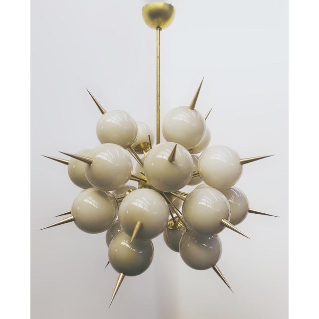 Italian sputnik chandelier with 24 Murano glass globes and solid brass spikes mounted on brass frame in unlacquered...
