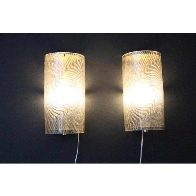 This magnificent pair of glass wall sconces is made of frosted Murano graniglia glass and brass. A very unusual design....