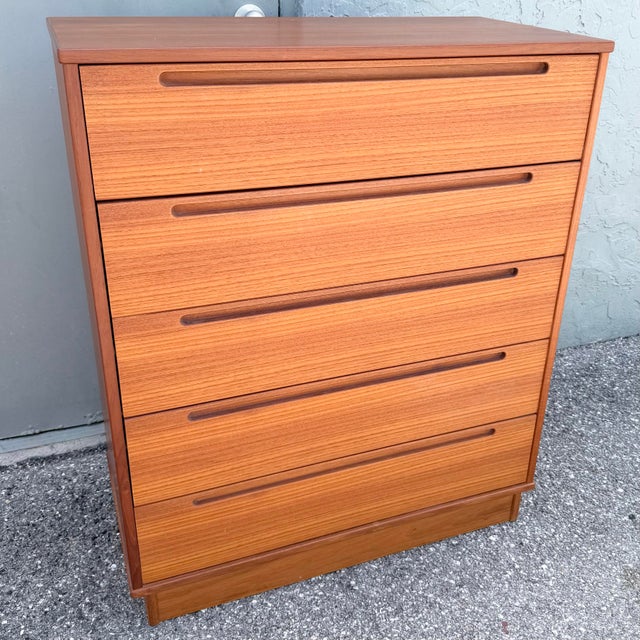 Classic Danish Modern teak tallboy dresser designed by Nils Jonsson for Tørring Møbelfabrik. The streamlined case features...