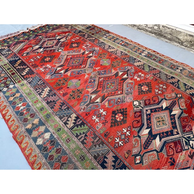 A vintage Caucasian rug in the Shirvan/Kuba tradition — four hooked diamond medallions with floral cores stacked in a pole...