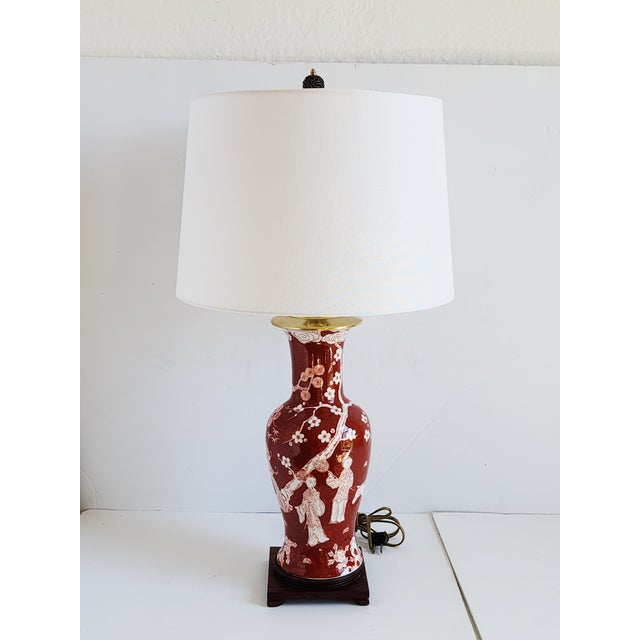 Vintage Mid-Century Chinoiserie style porcelain red brick and white table lamp featuring figural Chinese sceneries with...