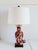 Vintage Mid-Century Chinoiserie style porcelain red brick and white table lamp featuring figural Chinese sceneries with...
