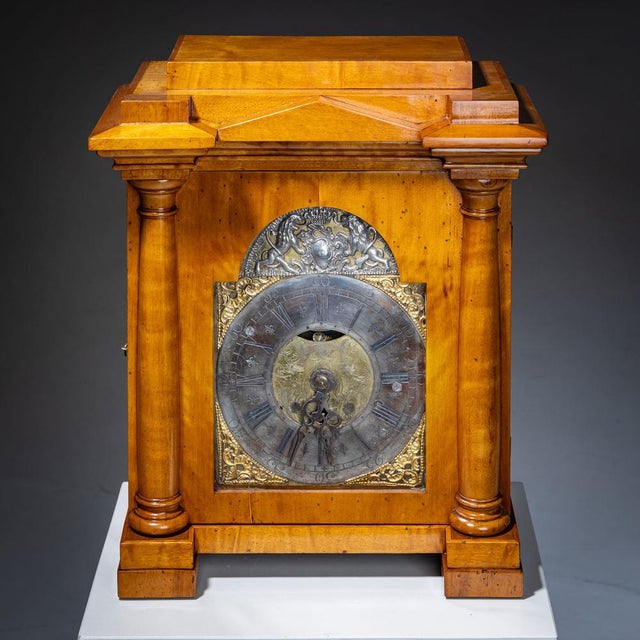 A "marriage" combining a Baroque bronze wall clock with a Biedermeier case in the form of a temple. The case, crafted from...