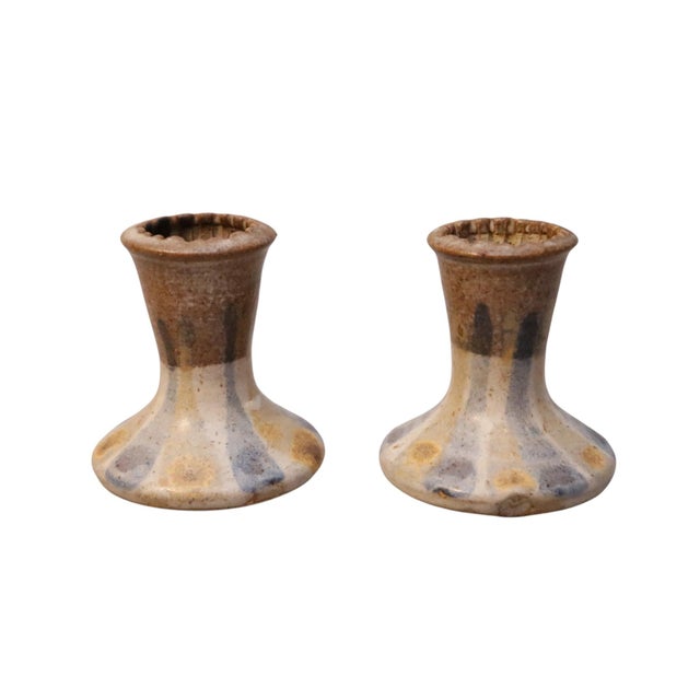 A pair of hand thrown candle holders attributed to American potter Donn Young. Vase shaped and decorated with yellow and...