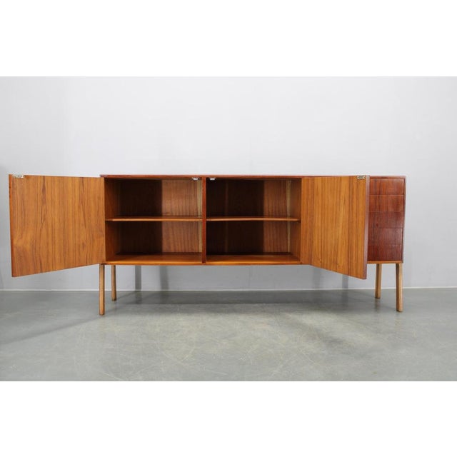 This elegant Mid-Century sideboard was produced in Denmark during the 1960s. Constructed from solid oak with rich teak...