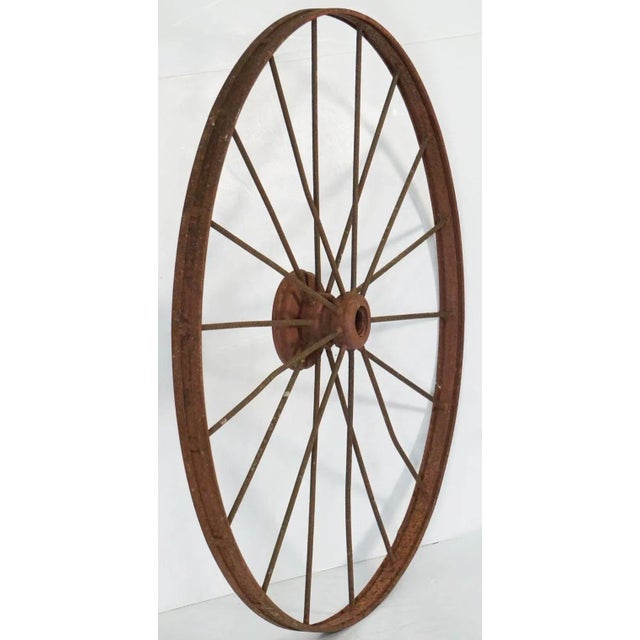 A handsome large English spoked cart or wagon wheel (54 inches diameter) of iron from the late 19th century, with 18...