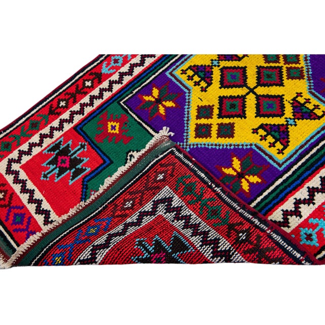 Beautiful vintage Turkish hand-knotted wool rug with a red field. This rug has a red and white designed frame and...