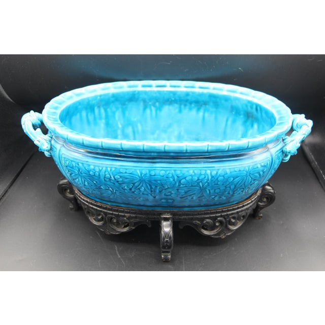 Oval blue glazed ceramic planter with a foliage design and dragon-shaped handles signed underneath with its original...