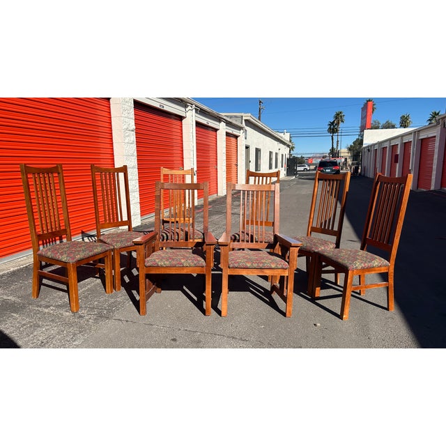 Authentic vintage set of 8 Bassett dining chairs from the late 20th century. Crafted in warm solid oak with tall vertical...