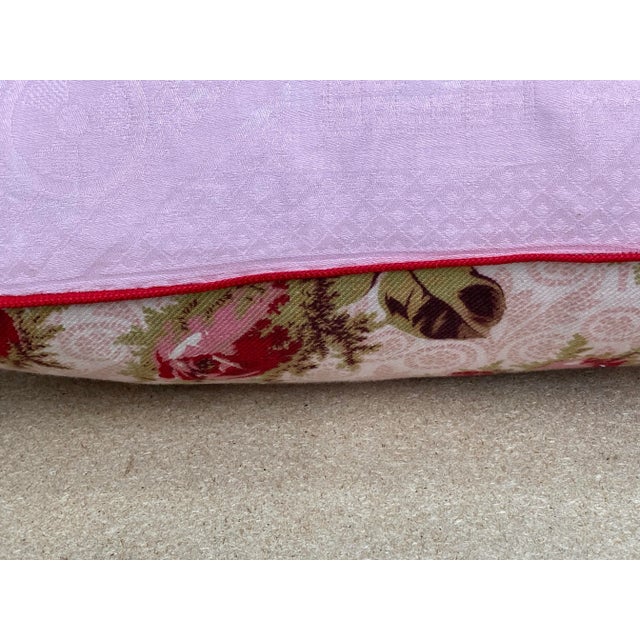 A pillow made from a circa the 1880s printed cotton with a rose bud scattered motif. A down insert is included.
