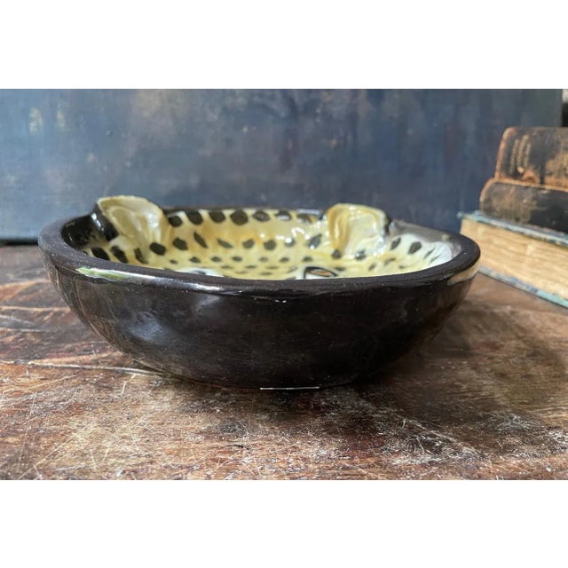 Absolutely gorgeous bowl depicting a leopard in the center, in relief with the ears just pushing out side of the rim of...