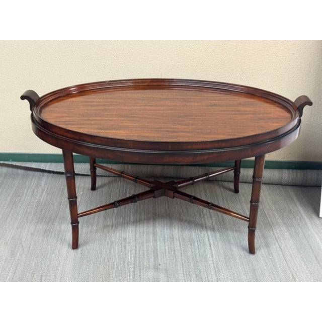 Design Plus Gallery presents an Aged Regency Coffee Table from Maitland Smith. The table has an oval shape with a medium...