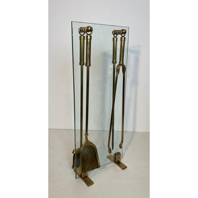 This beautiful and elegant designer fireplace tool is made of glass with brass elements and tools. It is a French work....