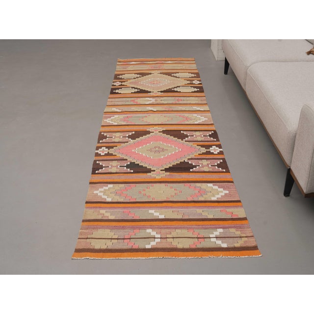Vintage Hand-Knotted runner rug is a semi-antique vintage area rug. The '70s Eastern region of Anatolia's unique rug is...