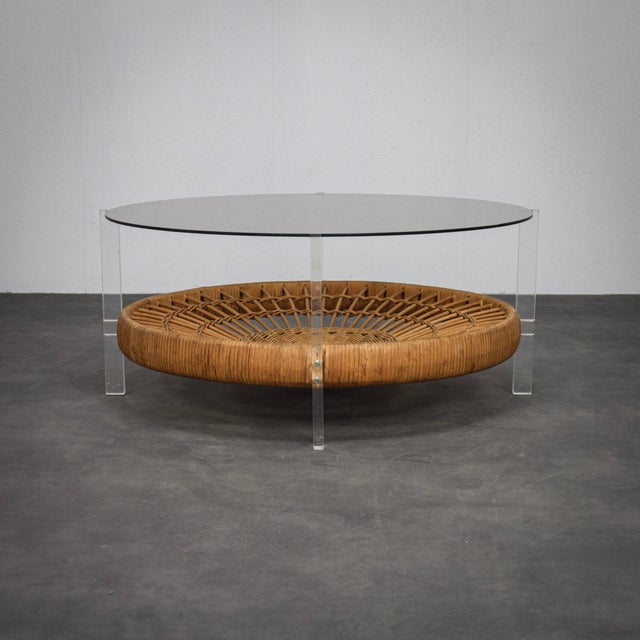 A beautiful and playful coffee table from the 1970s, featuring a striking mix of materials. The smoked glass top rests on...