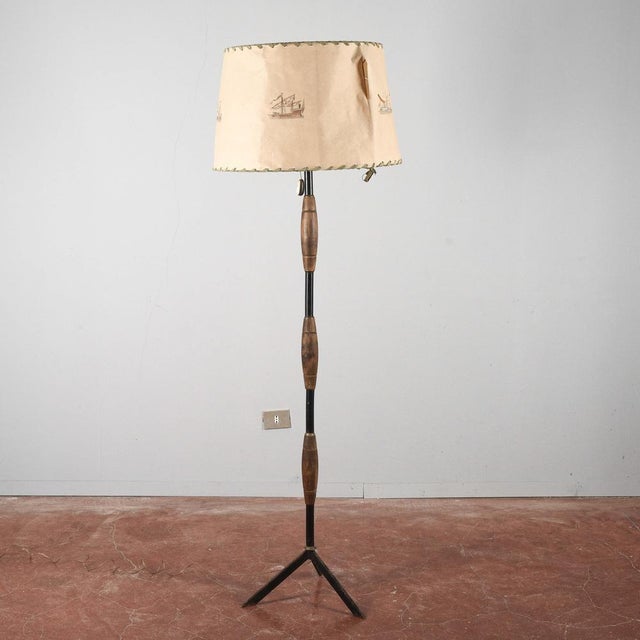 This art deco floor lamp is a vintage piece crafted in the stilnovo style, featuring the original parchment lampshade,...