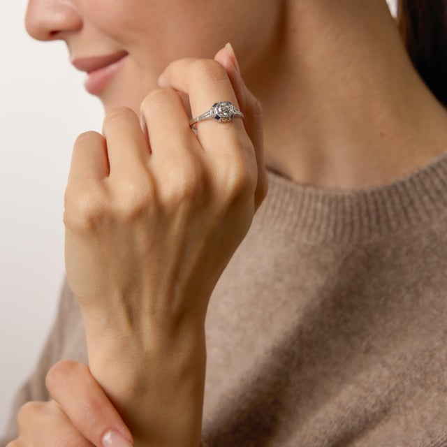 A refined expression of 1930s elegance, this authentic Art Deco engagement ring showcases a 0.65 carat old European cut...