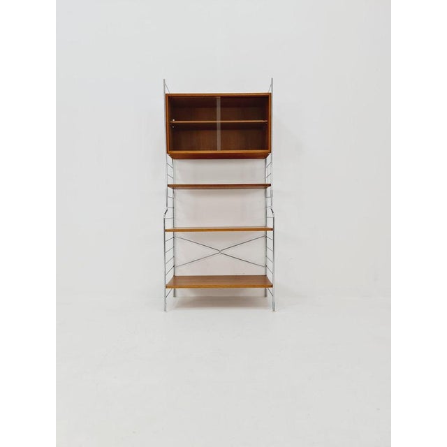 Free standing String shelf system, bookcase with cabinet teak by WHB Germany, 1950s The bookshelf system is in great...
