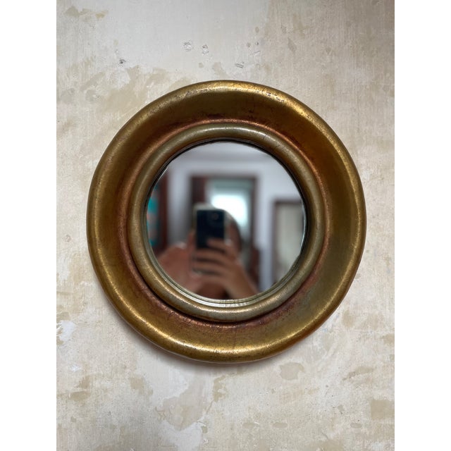A small circular portal mirror with a gold leaf finish. Made in the 1950s of a very durable plastic that has the...