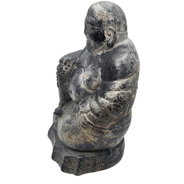 Weathered by time and softened by seasons, this cement Laughing Buddha radiates a quiet, grounded joy. With prayer beads...