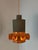 This orange-brown ceramic lamp in the style of West German Pottery combines stylish craftsmanship with a warm color...