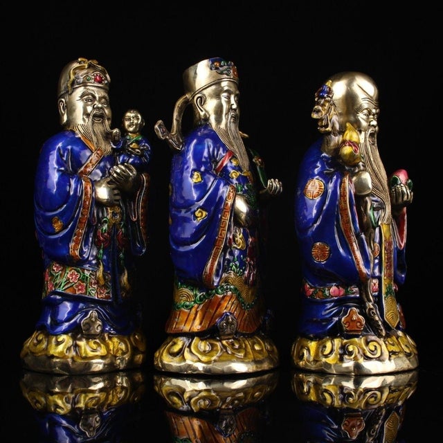 This is an impressive set of three antique gilt bronze and enamel figures representing Fu, Lu, and Shou, the three star...
