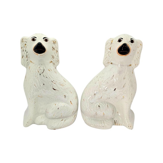 A matched facing pair of Victorian Staffordshire spaniel mantel figures dating to circa 1860–1880. Each seated dog is...