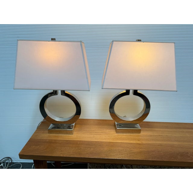Design Plus Gallery presents a Pair of Chrome Ring Form Table Lamps. The have contemporary styling with a transition edge...