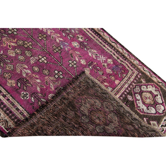 Beautiful Vintage Persian distressed hand-knotted wool runner with a purple color field. This piece has a beige frame and...