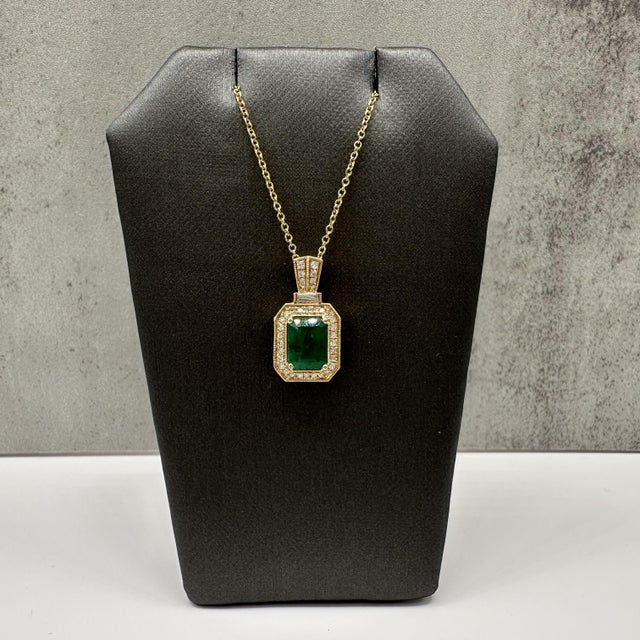 This designer Effy pendant necklace is crafted in 14kt yellow gold and showcases a stunning 1.42 carat emerald cut green...
