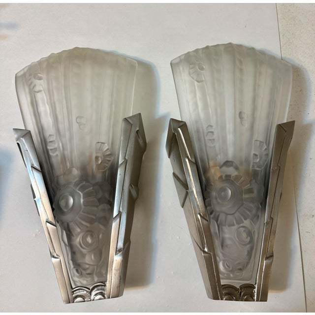 A pair of French Art Deco wall sconces by French artist Genet et Michon. Having a clear and frosted glass shade with...