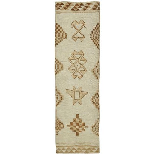 This exquisite runner rug is a rare example of tribal craftsmanship, hand-knotted by the women of the Herki tribe during...