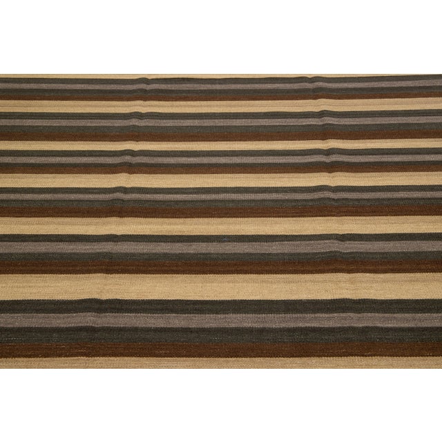 Beautiful Modern Kilim hand-knotted wool rug with multicolor accents in an all-over geometric stripe design. This rug...